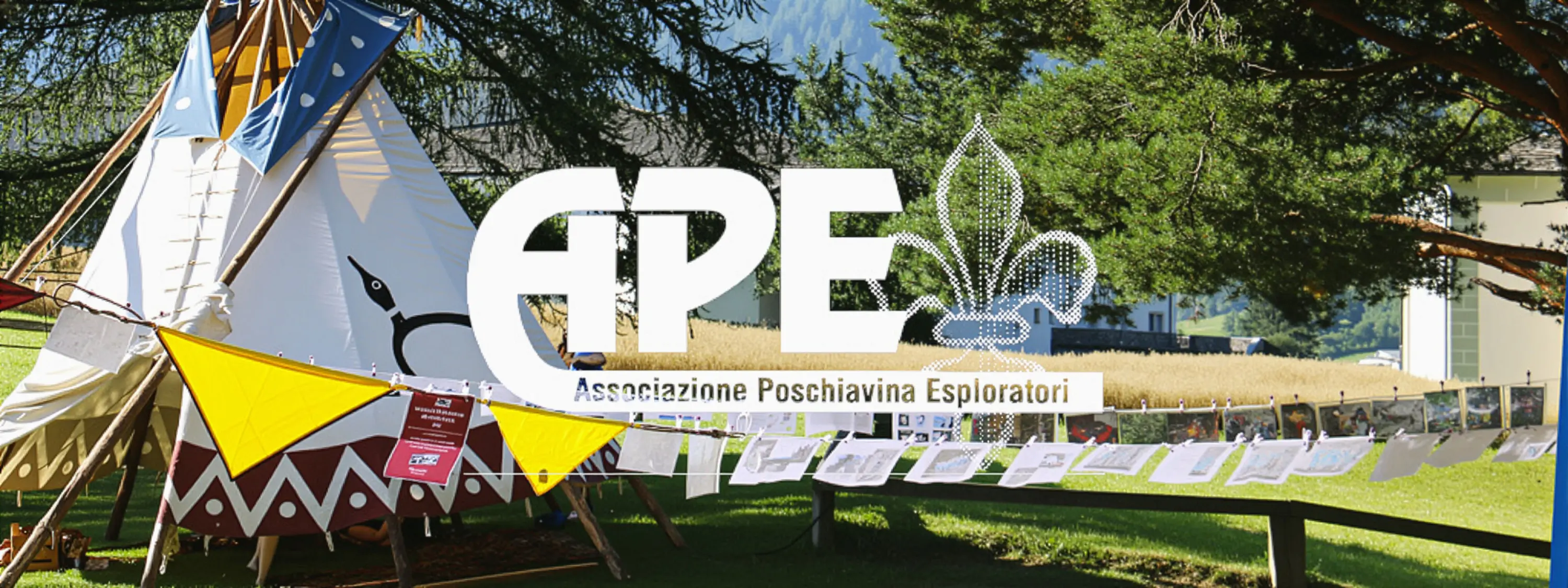 Tenda tradizionale con bandiere colorate e fotografie appese, circondata da un paesaggio naturale. Logo dell'Associazione Poschiavina Esploratori in evidenza.