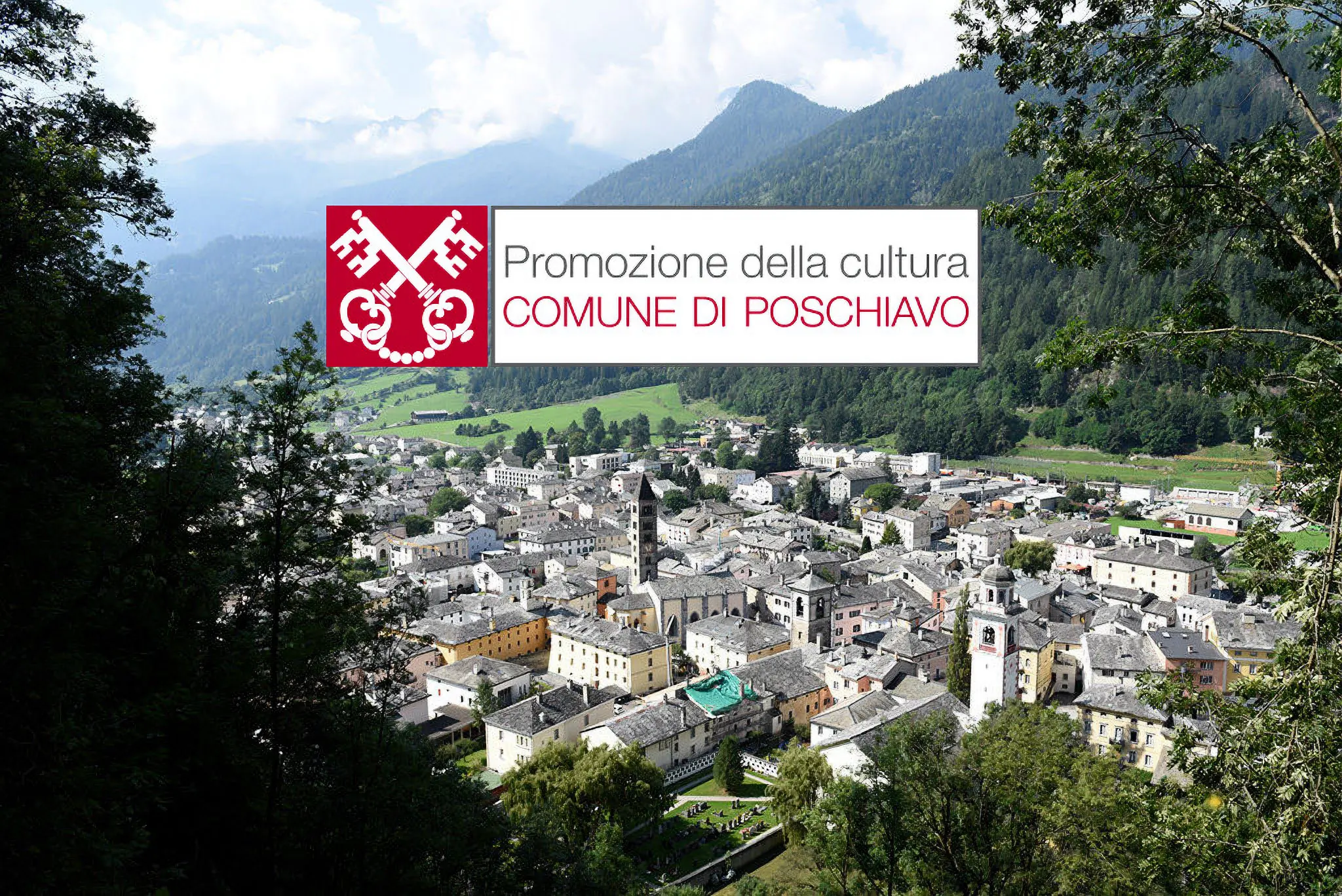 Panoramica di Poschiavo, un comune nelle Alpi svizzere, con case storiche e montagne sullo sfondo. Un logo rosso e bianco con simboli heraldrici è sovrapposto all'immagine.